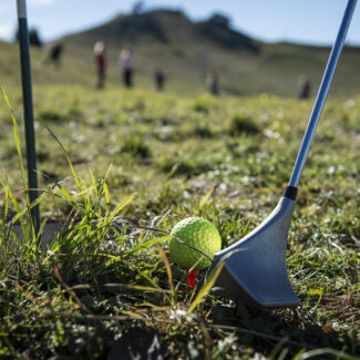 Vue rapprochée d'une balle de Swin golf et du club, mettant en avant les détails du matériel de l'activité