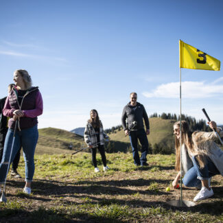 Un groupe d'amis se regroupe autour d'un des trous sur le parcours de Swin golf de Charmey