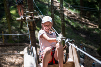 Une fille s'amuse sur l'accrobranche de Charmey