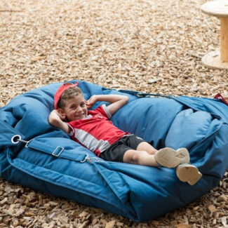 Un enfant se repose sur un énorme pouf